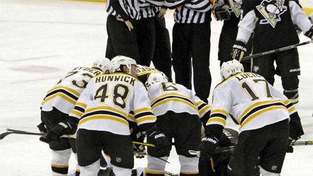 The Boston Bruins lean over fallen teammate Marc Savard after a hit in the third period.



