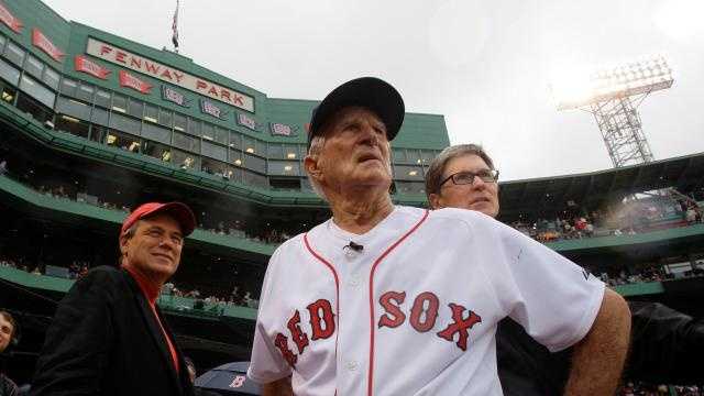 Boston Red Sox great Johnny Pesky, center, is flanked by team president Larry Lucchino, left, and owner John Henry as they look past Pesky's Pole where Pesky's No. 6 adorns the upper deck during a ceremony to retire his number prior to a baseball game against the New York Yankees at Fenway Park in Boston, Sunday Sept. 28, 2008.