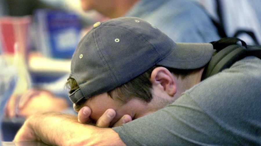 Craig McFarland holds his head at the ticket counter of American Airlines. McFarland, who exchanged his ticket, says he was supposed to leave on American Flight 11 which left Boston and crashed into the World Trade Center. 