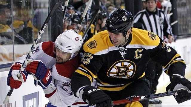 Boston Bruins defenseman Zdeno Chara (33) checks Montreal Canadiens right wing Brian Gionta (21) against the boards as they chase the puck during the first period of an NHL hockey game in Boston, Wednesday, Feb. 9, 2011.