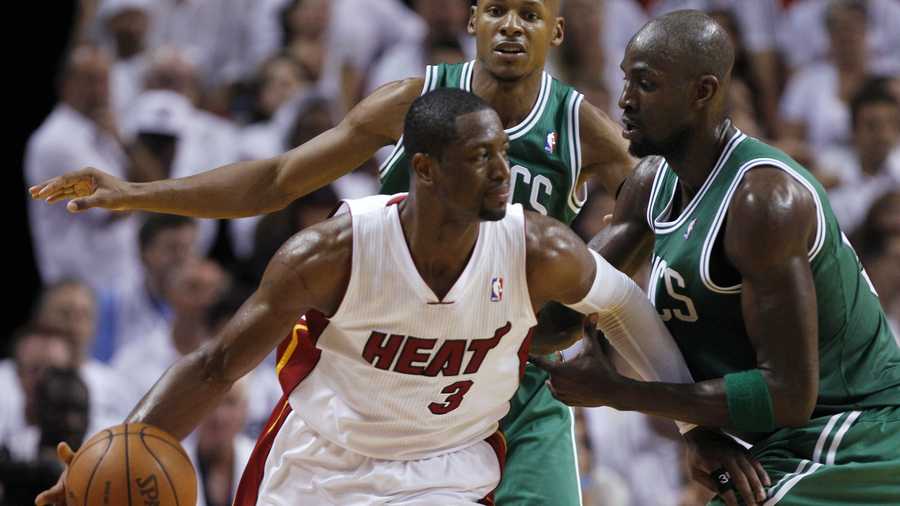 Miami Heat's Dwyane Wade dribbles as Boston Celtics' Kevin Garnett, right, defends.