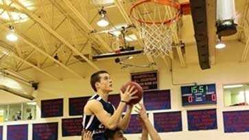 Joey Mullaney, a senior at Lawrence Academy, makes a slam dunk with the help of his teammates.