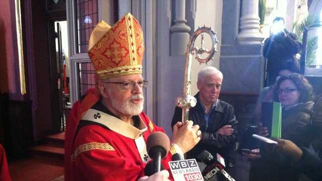 Cardinal Sean O'Malley talks with reporters at the Cathedral of the Holy Cross on Palm Sunday, March 24, 2013.