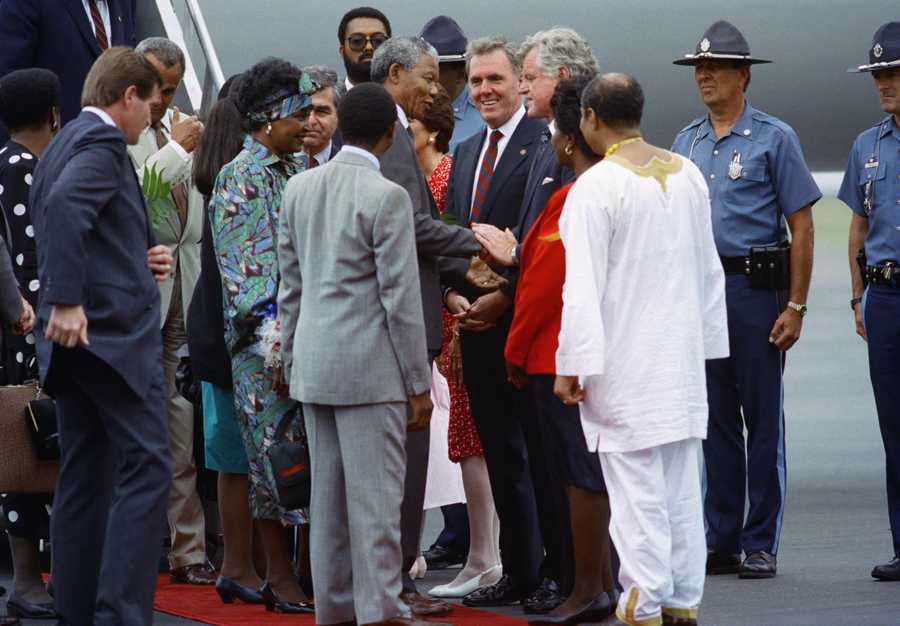 Nelson Mandela, left center, shakes hands with Sen. Edward Kennedy after Mandela's arrival at Logan International Airport,June 23, 1990. Boston Mayor Ray Flynn looks in between the two men. At far left in Mandela's wife Winnie with Massachusetts Gov. Michael Dukakis in background.