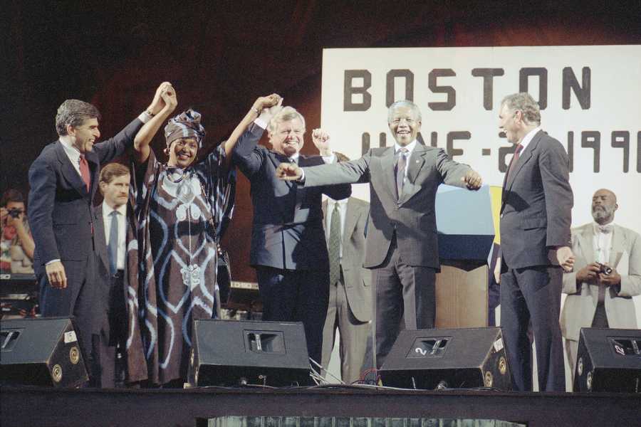 Nelson Mandela, center, dances to African folk music during the rally and concert at the Hatch Shell on Boston’s Esplanade, June 23, 1990. Mandela was joined by U.S. Senator Edward Kennedy, left, and Boston Mayor Ray Flynn.