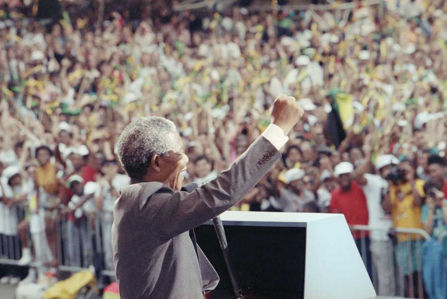 African National Congress deputy president Nelson Mandela gives a raised fist salute to the crowd at the Esplanade in Boston, June 23, 1990, where over 200,000 people gathered to see Mandela.