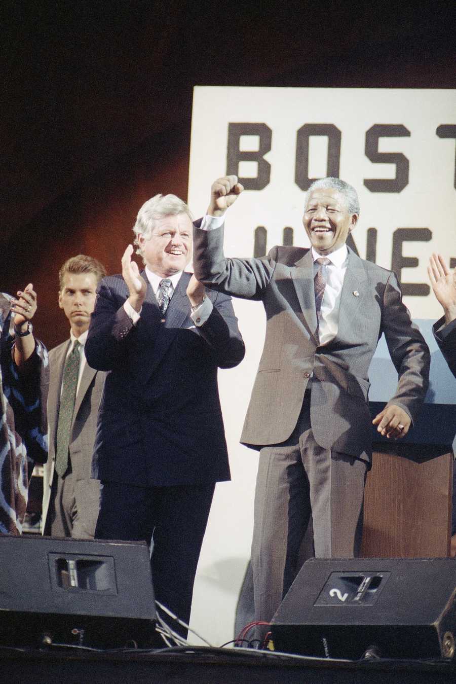 Nelson Mandela, deputy President of the Africa National Congress, moves to the music as Sen. Edward Kennedy applauds at a rally in Mandela's honor at the Esplanade in Boston, June 23, 1990, before a crowd of more than 200,000 people.