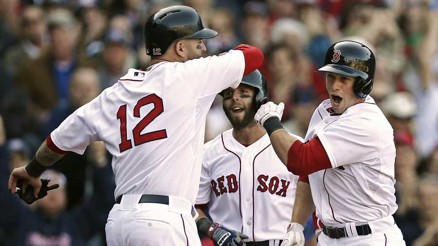 Daniel Nava, right, is greeted by Dustin Pedroia and Mike Napoli (12) after hitting a three-run home run during the seventh inning against the Baltimore Orioles at Fenway Park, April 8, 2013.