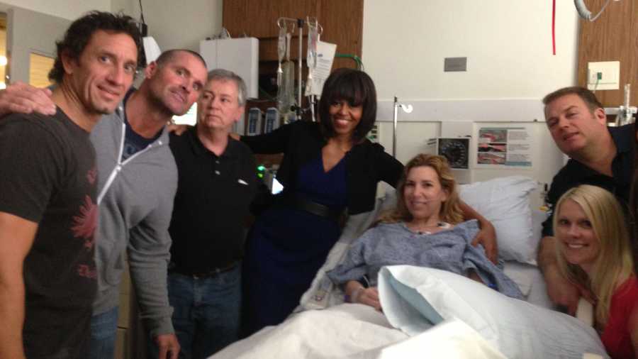 This April 18, 2013 photo provided by Alfred Colonese shows from left Alfred Colonese, Mick Henn, Dale Abbott, first lady Michelle Obama, Heather Abbott, Jason Geremia, and Michelle Dalrymple at Brigham and Women's Hospital in Boston. Heather Abbott was scrambling to get off the sidewalk when the force of the second blast blew her through the restaurant doorway. The day of the bombings, Abbott and a half-dozen friends took in the traditional Patriots' Day Red Sox game at Fenway Park. They left the match early and headed to Forum, where former New England Patriots were gathered to raise money for offensive guard Joe Andruzzi's cancer foundation, and where another friend was tending bar.