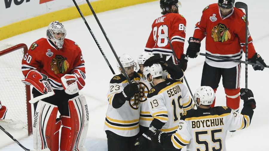 Boston Bruins center Chris Kelly (23) celebrates with teammates as Chicago Blackhawks goalie Corey Crawford (50) looks on after Kelly scored a goal in the second period during Game 2 of the NHL hockey Stanley Cup Finals, Saturday, June 15, 2013, in Chicago.