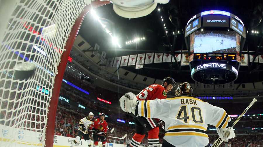 The puck flies into the net as Chicago Blackhawks center Andrew Shaw (65) scores the game winning goal against Boston Bruins goalie Tuukka Rask (40) during the third overtime period of Game 1 in their NHL Stanley Cup Final hockey series, Wednesday, June 12, 2013, in Chicago. The Blackhawks won 4-3