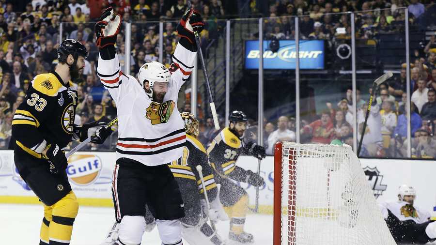 Chicago Blackhawks left wing Brandon Saad, center, celebrates a goal by Blackhawks center Michal Handzus, right, in front of Boston Bruins defenseman Zdeno Chara (33) during the first period in Game 4 of the NHL hockey Stanley Cup Finals, Wednesday, June 19, 2013, in Boston. 