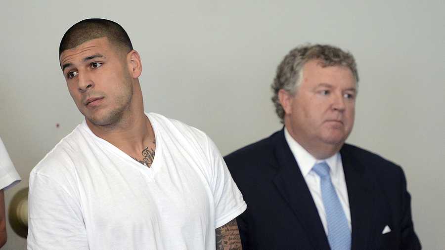 Former New England Patriots tight end Aaron Hernandez, left, stands with his attorney Michael Fee, right, during arraignment in Attleboro District Court Wednesday, June 26, in Attleboro, Mass.