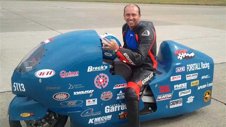 In this 2011 photo provided by the Loring Timing Association the late Bill Warner, 44, of Wimauma, Fla., holds his helmet while sitting on a motorcycle.