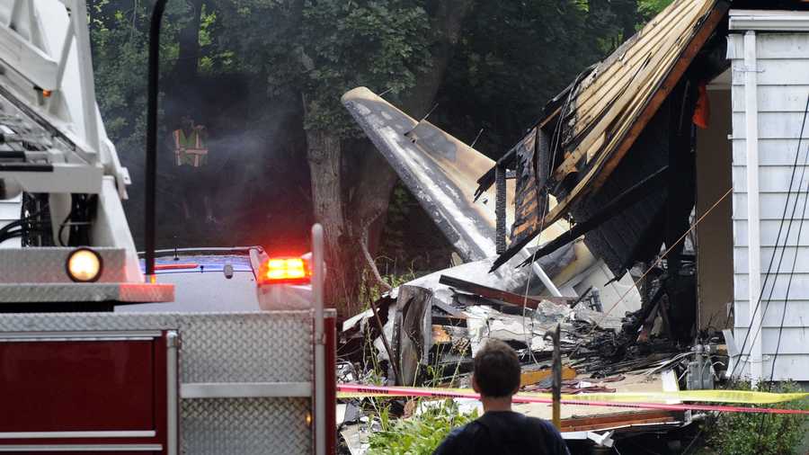A firefighter surveys the scene of a small plane crash, Friday, Aug. 9, 2013, in East Haven, Conn. The multi-engine, propeller-driven plane plunged into a working-class suburban neighborhood near Tweed New Haven Airport, on Friday.