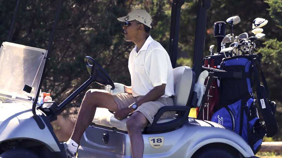 President Barack Obama steers his cart while golfing at Farm Neck Golf Club in Oak Bluffs, Mass., on the island of Martha's Vineyard Sunday, Aug. 11, 2013.