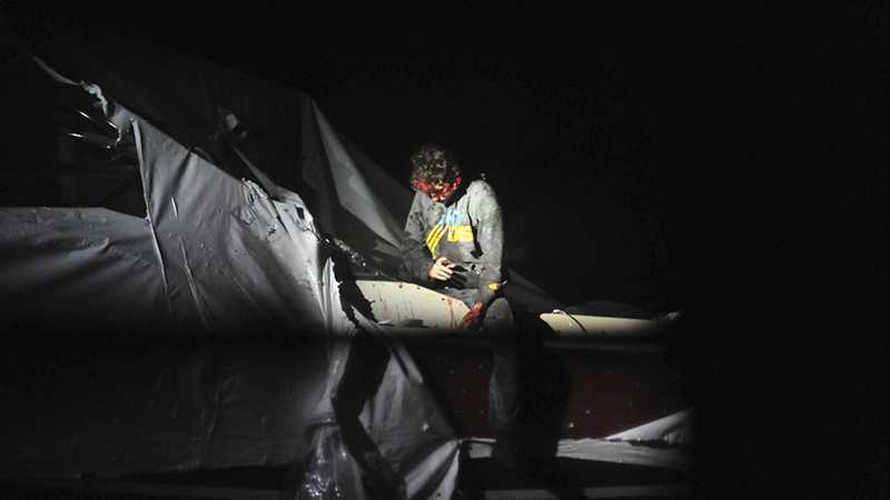 Boston Marathon bombing suspect Dzhokhar Tsarnaev leans over in a boat at the time of his capture by law enforcement authorities in Watertown, Mass. Photos of the Boston Marathon bombing suspect's surrender have been posted on the Boston Magazine website. The additional images, made public Tuesday, Aug. 27, were among those released to the magazine last month by a state police photographer. 