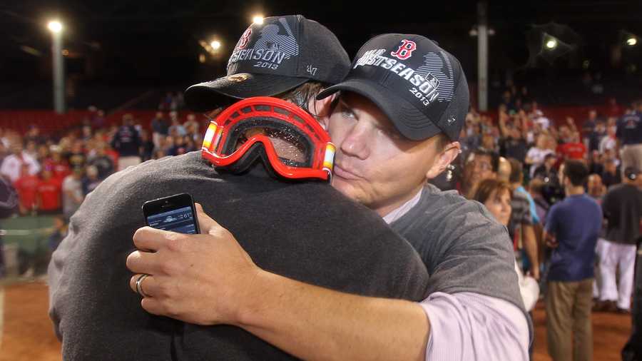 Boston Red Sox general manager Ben Cherington, right, is embraced by a player after the Red Sox clinched the AL East title with a 6-3 win over the Toronto Blue Jays in a baseball game at Fenway Park, Friday, Sept. 20, 2013, in Boston. 
