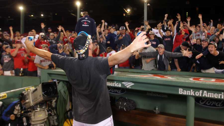 Boston Red Sox catcher Ryan Lavarnway celebrates with fans after the Red Sox clinched the AL East title with a 6-3 win over the Toronto Blue Jays in a baseball game at Fenway Park, Friday, Sept. 20, 2013, in Boston. 
