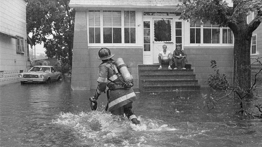A firefighter makes his way through knee-deep water as he checks flooding conditions on Gordon Place in Freeport, New York, Sept. 27, 1985. Howling winds and heavy rain from Hurricane Gloria flooded local streets as the storm passed over the Long Island community.