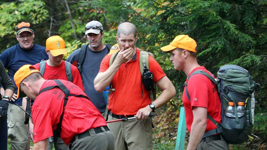 New Hampshire Fish and Game personnel and volunteers take a break after searching the woods for 14-year-old Abigail Hernandez.