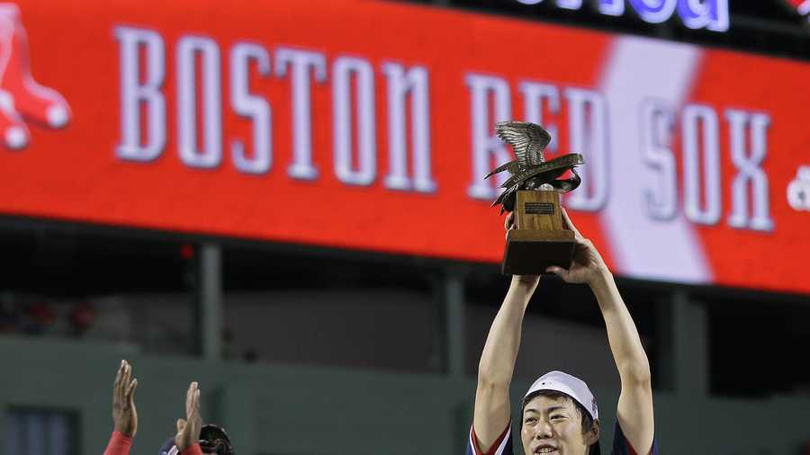 Boston Red Sox relief pitcher Koji Uehara hoists the most valuable player trophy after the Red Sox beat the Detroit Tigers 5-2 in Game 6 of the American League baseball championship series on Saturday, Oct. 19, 2013, in Boston. Uehara was named the series MVP, and the Red Sox advance to the World Series. 