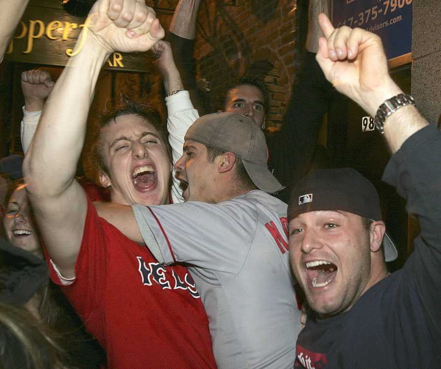 Former Boston Red Sox pitchers Curt Schilling, far right, and Keith Foulke,  holding the 2004 World Series trophy, and catcher Jason Varitek, far left,  applaud as 2004 teammate David Ortiz (34) joins