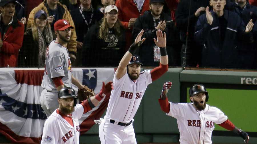 St. Louis Cardinals starting pitcher Adam Wainwright, left, rear watches as Boston Red Sox's Jonny Gomes, left, Jacoby Ellsbury, center, and Dustin Pedroia, celebrate a three-run scoring double by Mike Napoli during the first inning of Game 1 of baseball's World Series Wednesday, Oct. 23, 2013, in Boston. 