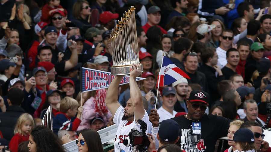 Boston Red Sox's Shane Victorino holds the World Series trophy from on Duck Boat during a victory parade celebrating the team's third World Series title since 2004, Saturday, Nov. 2, 2013, in Boston.