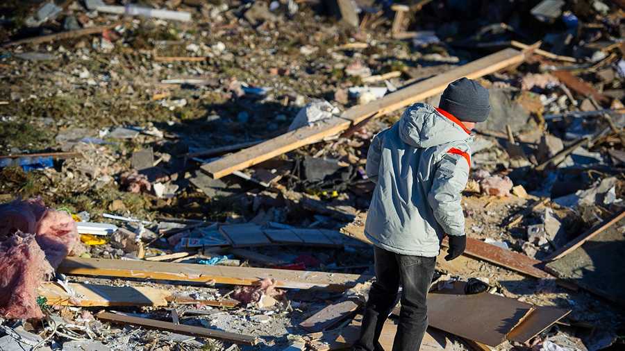 In an November 2013 family photo provided by Annmarie Klein, Brady Klein, 11, walks through the rubble of his family’s home in Washington, Ill., after it was leveled Nov. 17 by a tornado. Brady’s mother, Annmarie Klein, is asking for the public’s help in locating three cards swept away by the twister, each of which Klein’s brother, Paul McLaughlin, personalized with a note before his 2005 death from colon cancer. McLaughlin had entrusted Klein to give the cards to his children someday.