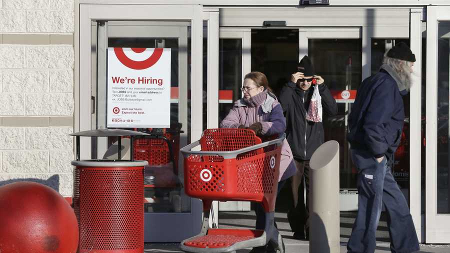 A woman pushes a shopping cart, center left, while departing a Target retail store Thursday, Dec. 19, 2013 in Watertown, Mass. Target says that about 40 million credit and debit card accounts may have been affected by a data breach that occurred just as the holiday shopping season shifted into high gear.