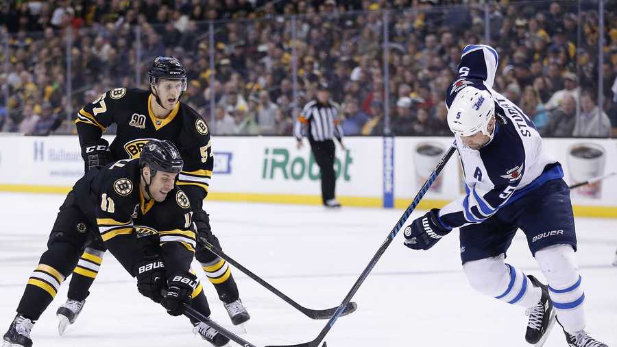 Boston Bruins' Gregory Campbell (11) and Winnipeg Jets' Mark Stuart (5) battle for the puck in the second period of an NHL hockey game in Boston, Saturday, Jan. 4, 2014.