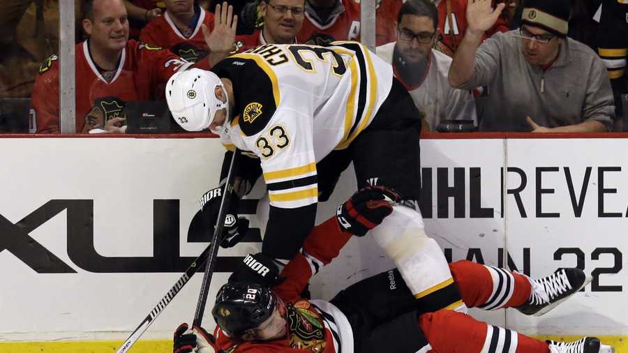 Chicago Blackhawks' Brandon Saad (20), bottom, is checked by Boston Bruins' Zdeno Chara (33) during the second period of an NHL hockey game in Chicago, Sunday, Jan. 19, 2014.