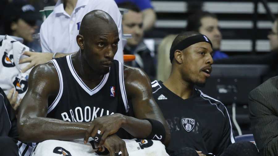 Brooklyn Nets forwards Kevin Garnett, left, and Paul Pierce, right, watch from the bench as their teammates play the Detroit Pistons during the first half of an NBA basketball game Friday, Dec. 13, 2013, in Auburn Hills, Mich. (AP Photo/Duane Burleson)