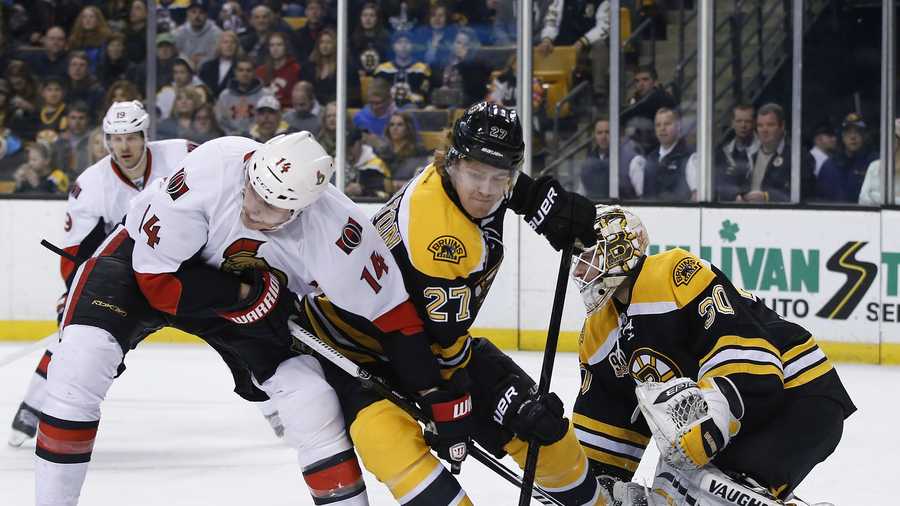 Boston Bruins defenseman Dougie Hamilton (27) keeps Ottawa Senators left wing Colin Greening (14) from getting position as Boston Bruins goalie Chad Johnson (30) protects the net during the first period of an NHL hockey game in Boston, Saturday, Feb. 8, 2014. (AP Photo/Elise Amendola)