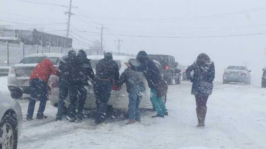 A group of people push a stuck car on Route 1 in Saugus.