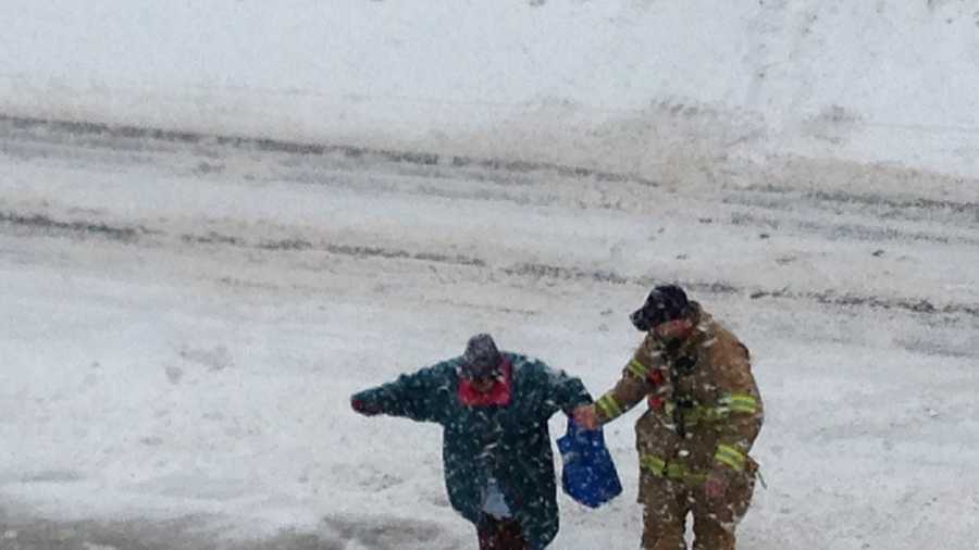 Heavy snow throughout the day made the trip difficult, so he got out of the apparatus to help her across the street.