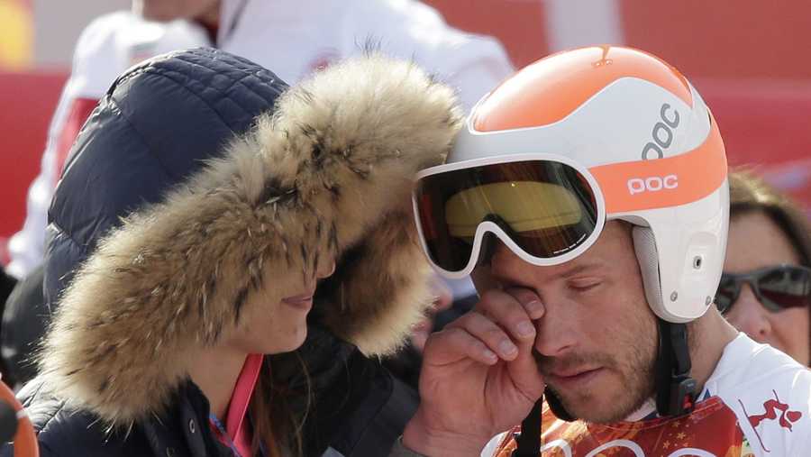 United States' Bode Miller wipes his face as he stands with his wife, Morgan, after finishing the men's super-G at the Sochi 2014 Winter Olympics, Sunday, Feb. 16, 2014, in Krasnaya Polyana, Russia.