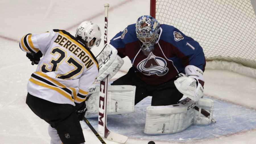Boston Bruins center Patrice Bergeron (37) scores on Colorado Avalanche goalie Semyon Varlamov (1) the first period of an NHL hockey game in Denver on Friday, March 21, 2014.