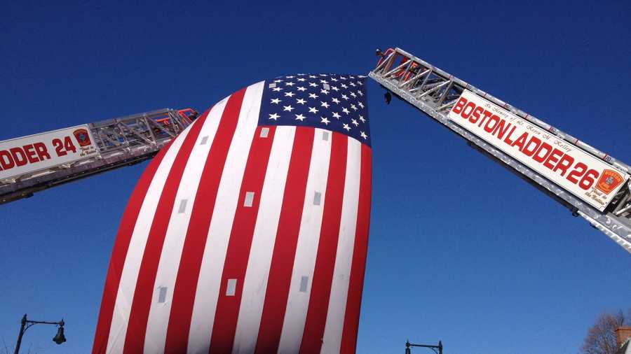 The flag on two Boston ladder trucks across Centre Street.