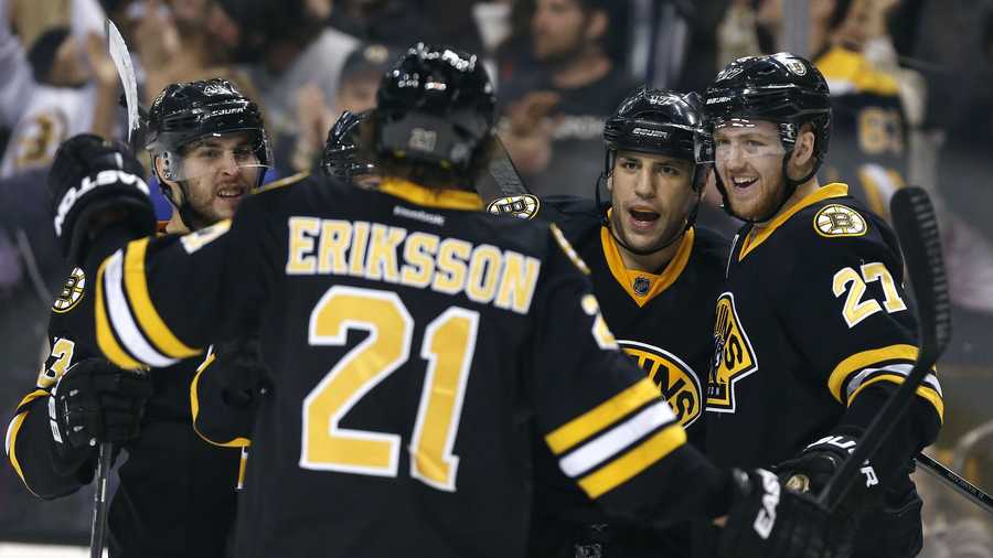 Boston Bruins' Milan Lucic (17) celebrates his goal with teammates Dougie Hamilton (27) and Loui Eriksson (21) in the second period of an NHL hockey game against the Philadelphia Flyers in Boston, Saturday, April 5, 2014. (AP Photo/Michael Dwyer)