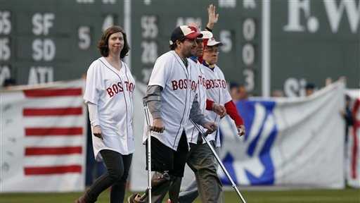 Boston Marathon bombing survivors including Jeff Bauman, center left, and Carlos Arredondo, center right, walk onto the field at Fenway Park during ceremonies marking the one-year anniversary of the bombing before a baseball game between the Boston Red Sox and the Baltimore Orioles in Boston, Sunday, April 20, 2014.