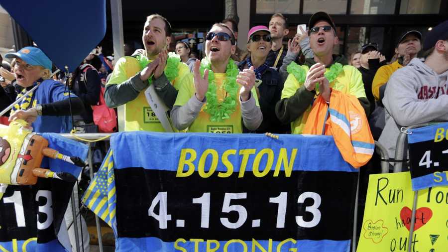 Race fans from left, Andrew Lembecke, of Chicago, Brandon Petrich of Fargo, N.D, Marlene Youngblood of Louisville, Ky, and Bill Januszewski cheer near the finish line at the 118th Boston Marathon Monday, April 21, 2014 in Boston.