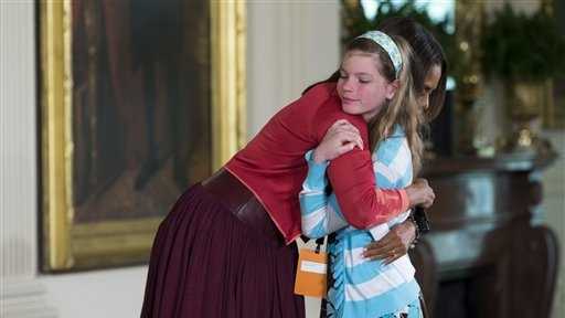 First lady Michelle Obama hugs Charlotte Bell, 10, after she handed Mrs. Obama her dad's resume during the White House's annual "Take Our Daughters and Sons to Work Day." The girl told the first lady that her dad had been out of work for three years. Then the girl popped up to hand Mrs. Obama her dad’s resume saying "My dad’s been out of a job for three years and I wanted to give you his resume."