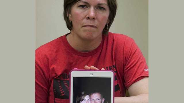 In this May 12, 2014 photo, Amy Miner, of Essex, Vt., poses in Burlington, Vt., with an April 2013 photo of herself and husband Kryn Miner, an Army veteran who suffered from Post Traumatic Stress Disorder, and who was shot to death by one of their children in April after threatening to kill the family. Amy Miner believes the Veterans Affairs health system must do more to help veterans who struggle with PTSD after returning home.