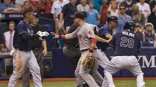 Boston Red Sox first baseman Mike Carp, center, confronts Tampa Bay Rays' Yunel Escobar, left, during a seventh- inning brawl of a baseball game against the Tampa Bay Rays Sunday, May 25, 2014 in St. Petersburg, Fla. Boston's Jonny Gomes was ejected along with Carp and Escobar.