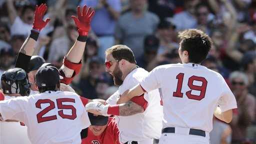 Boston Red Sox's Mike Napoli, center, is congratulated by teammates after his game-winning, walk off home run against the Minnesota Twins during the 10th inning of a baseball game at Fenway Park in Boston, Wednesday, June 18, 2014. The Red Sox won 2-1 in 10 innings.