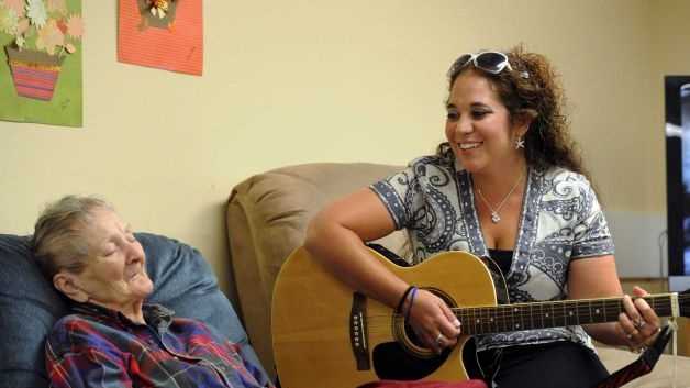 Brianna LePage, right, sings "Edelweiss" to Erika Groth who participates in The Gathering Place. LePage was trained in music therapy. She now uses her skills as a singer and musician to help those with dementia access their memory.