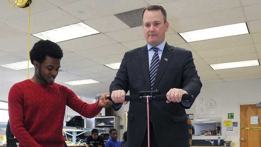 Former Lt. Gov. Timothy Murray, right, rides a Segway-like scooter made by student Adrian Niles, left, of Brockton, Mass., in an electronics class at the Southeastern Regional High School in Easton, Mass. on Wednesday, April, 3, 2013. Niles' success will take him to the White House in Washington, D.C., where he will display his creation to President Barack Obama.