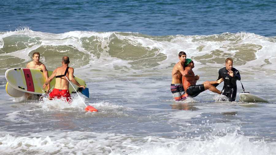 In this photo by Laura Joyce of goofyfootphotography.com, two men carry a swimmer, second from right, after he was bitten by a great white shark, as lifeguards close in at left in the ocean off Southern California’s Manhattan Beach, Saturday, July 5, 2014. The man, who was with a group of long-distance swimmers when he swam into a fishing line, was bitten on a side of his rib cage according to Rick Flores, a Los Angeles County Fire Department spokesman. The man’s injuries were not life-threatening and he was taken to a hospital conscious and breathing on his own, Flores said.